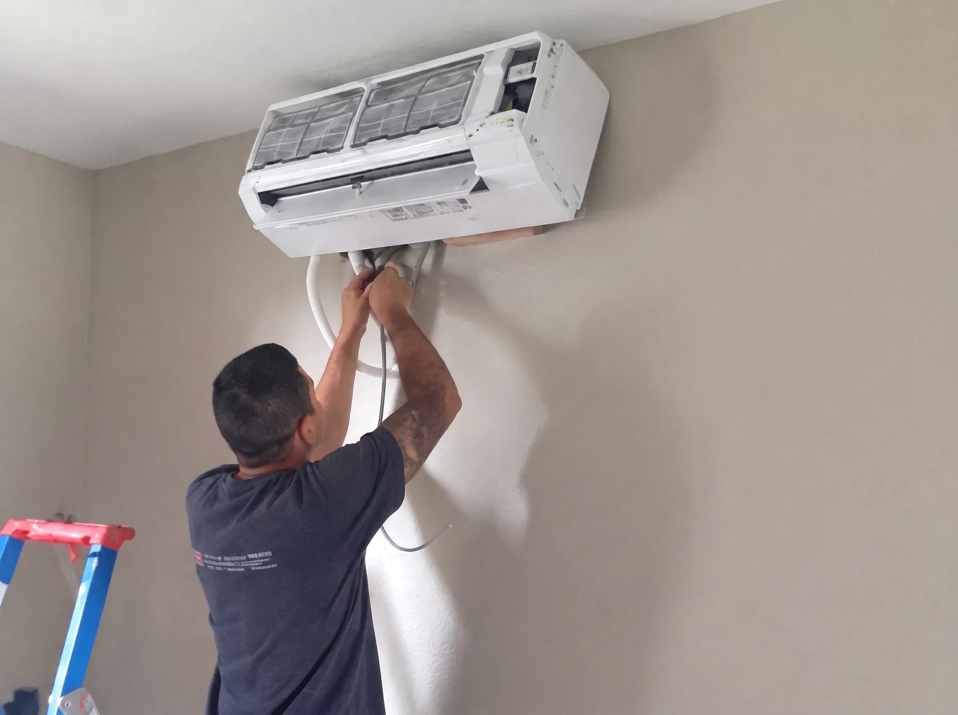 Extérieur d'une maison moderne avec pompe à chaleur air-eau installée sur socle béton